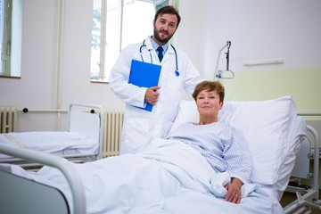 Obraz premium Smiling doctor and patient looking at camera in hospital
