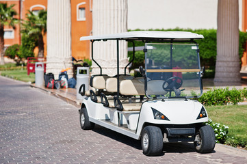 White golf car with back seat on resort.