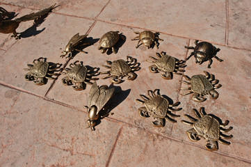 Golden metal figures of sea crabs, scarab beetle