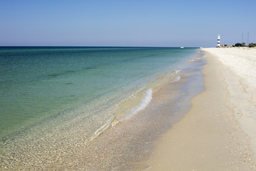 sunshine day on the sand beach with view to lighthouse