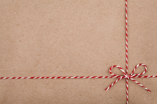 Christmas string or twine tied in a bow on kraft paper backdrop