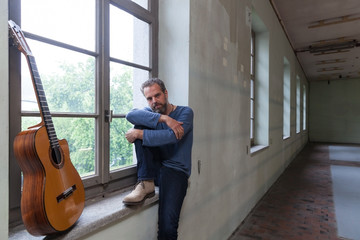 Portrait of man with guitar, the industrial location