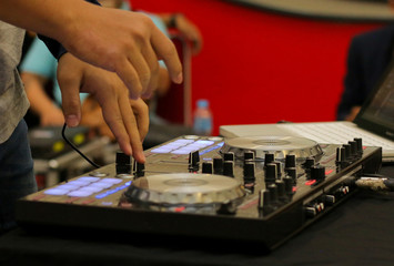 Dj mixes and playing the track controller turntable. New digital DJ technology for mixing audio tracks from notebook or flash drive.