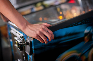 Young woman playing on the pinball machine - Powered by Adobe