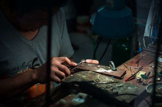 jeweler behind the glass. Work with jewelry - Powered by Adobe