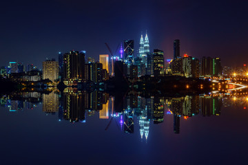 Fototapeta na wymiar Majestic view of Kuala Lumpur city skyline at night with full reflection.