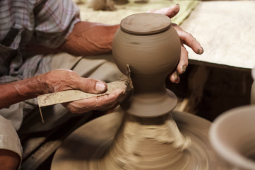 Fototapeta na wymiar Potter hands making in clay on pottery wheel.