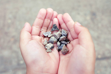 little girl hands holding small stones
