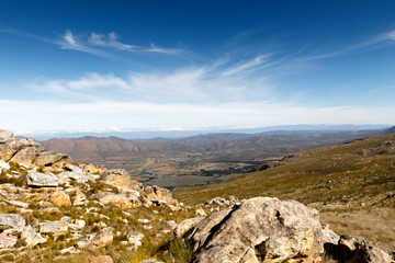 Green valley surrounded by mountains looking onto a plato