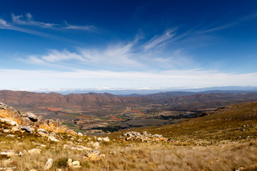Green valley surrounded by mountains with storm clouds