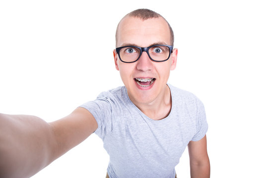 funny young man in glasses with braces on teeth taking selfie ph