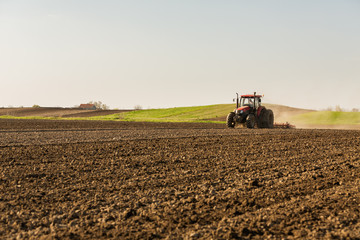 Farmer in tractor preparing land with seedbed cultivator