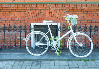 Fototapeta na wymiar White bike in front of a brick wall