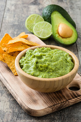 Nachos, guacamole and ingredients on wooden table

