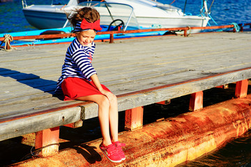 young girl sitting on the dock
