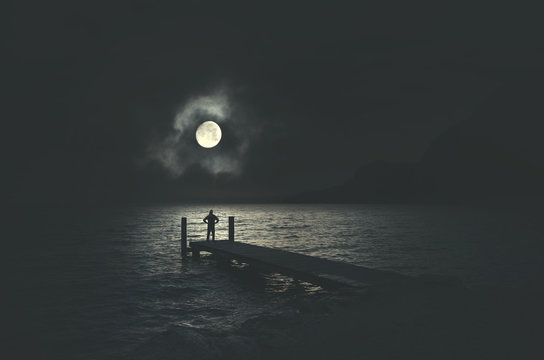 Man On A Boardwalk Observing Full Moon