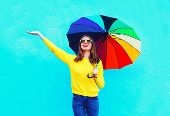 Happy smiling young woman with colorful umbrella in autumn day l