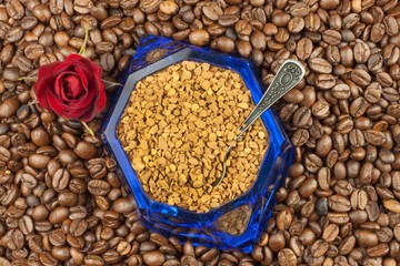 Coffee beans and instant coffee. Granules of instant coffee background. Instant coffee in a glass dish. Preparation of soluble coffee. Decorate store coffee.
