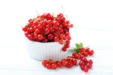 Red currant on a white wooden table