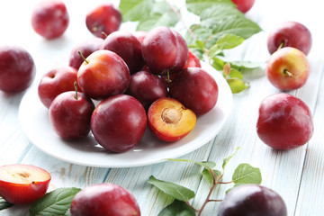 Fresh plums on a white wooden table