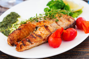 Grilled salmon steak with pesto sauce and vegetables