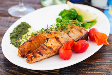 Grilled salmon steak with pesto sauce and vegetables