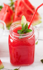 Fresh watermelon smoothies with lime and mint on white wooden background