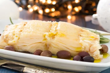 Rolgordijnen boiled cod fish with oil and olives on white dish © Natalia Mylova