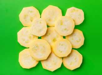 Zucchini sliced by rings folded in the form of a square to each other on green cutting board
