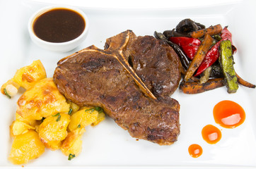 Pork chop with roasted potatoes with onions and steamed vegetables - zucchini, carrots, peppers and eggplant.