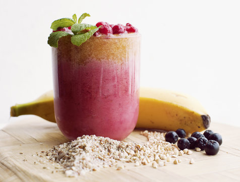 Strawberry smoothie with blueberry and banana on wooden table