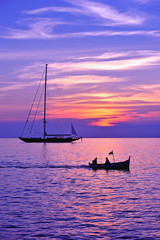 Fototapeta premium purple sky with boat and sailing ship silhouette
