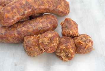 Bratwurst chunks and links on a cutting board.