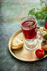 Mulled wine with apples, nuts and spices on copper tray. .