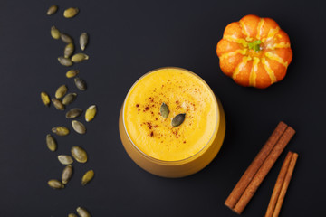 Pumpkin smoothie with pumpkin pie spices on a black slate stone background Top view. Copy space.