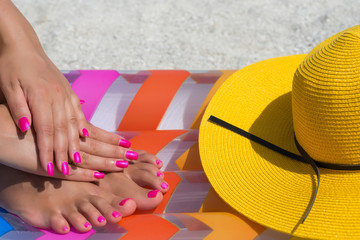 Close-up hand and foot on a pink air mattress in swimming pool.