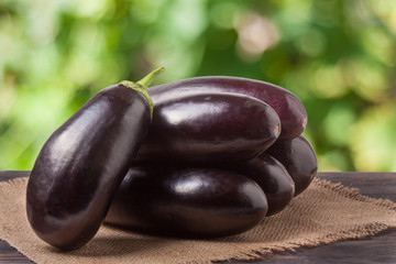 eggplant with a napkin of burlap on wooden table  blurred green background