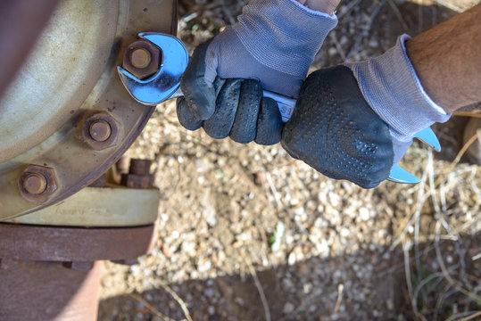 Wrench tightens a bolt / Workman at work in an old plumbing with equipment. 