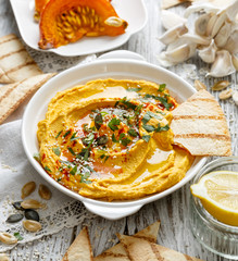 Roasted pumpkin hummus, creamy and delicious,  dip on a white plate