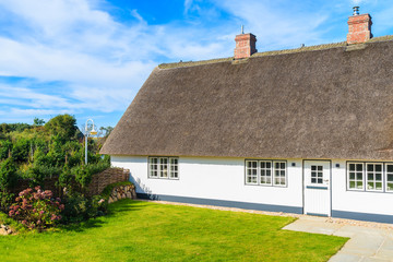 Fototapeta na wymiar Traditional white house with thatched roof in Wenningsted village on Sylt island, Germany