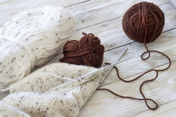 Fototapeta na wymiar Skeins of wool and knitting needles on wooden background