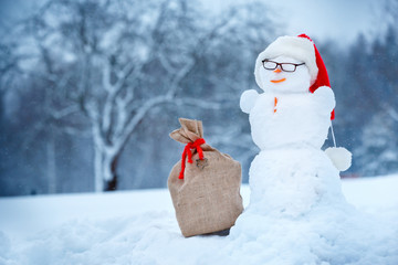 Snowman in Santa hat and sackcloth bag