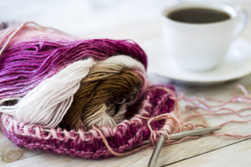 Skeins of wool and knitting needles on wooden background