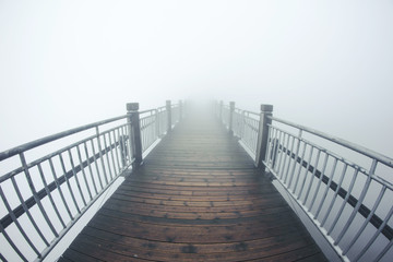 Mystic foggy wooden bridge background.