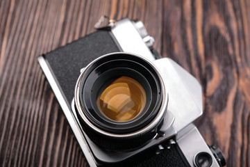 The old film camera on wooden table.