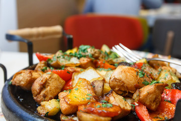 Meat baked with potatoes, vegetables and mushrooms in the pan.