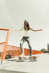 Teen girl skater riding skateboard on street.