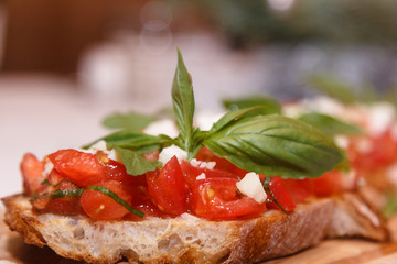 Bruschetta with tomatoes and Basil lies on a wooden Board
