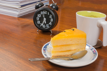 Coffee clock and Passion Fruit cakes on a wooden table backgroun