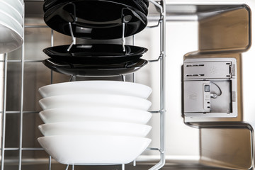 White and black plates in modern dishwasher machine